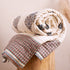 Royal umbrella hand block-printed quilt from Jaipur India, rolled on bed, showing cream cotton with umbrella motif, from WILLAGE