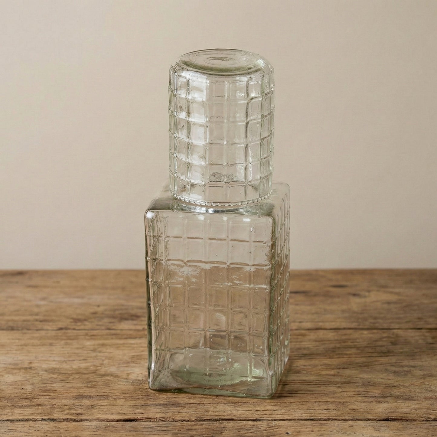 Multiple ruffle glass carafes with tumbler lids showing light catching the ribbed texture from different angles