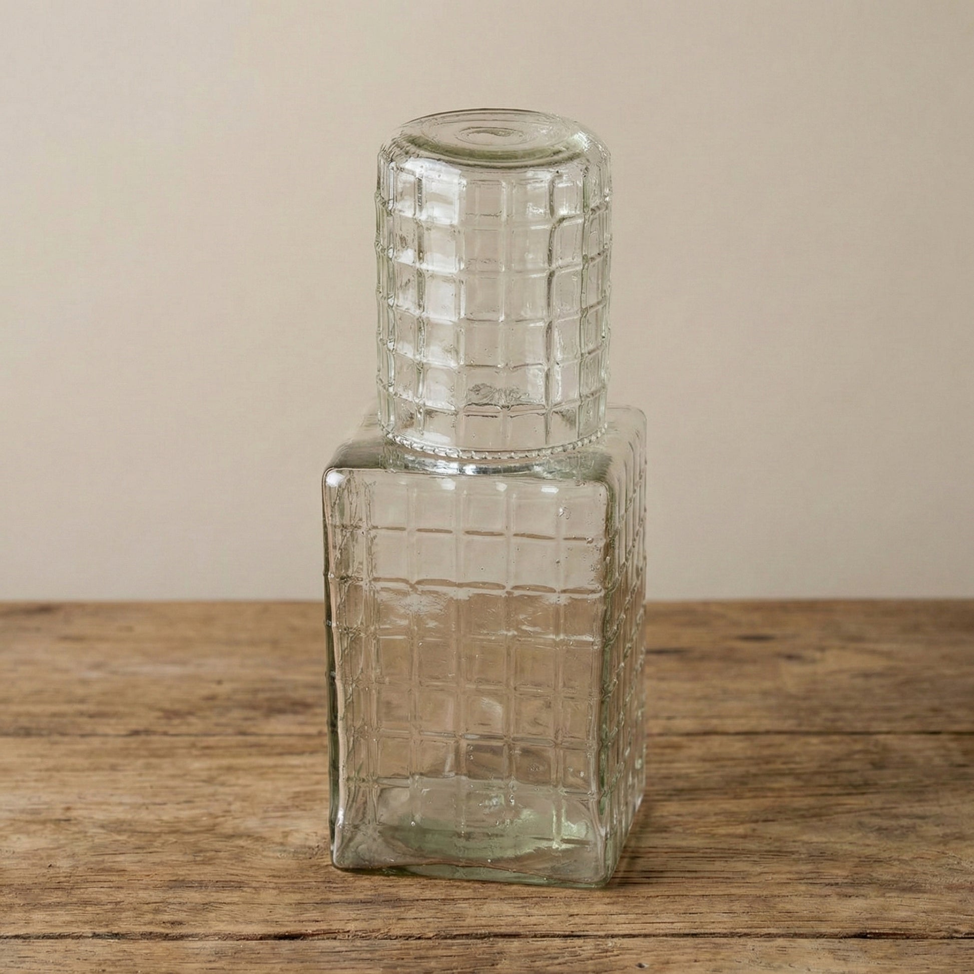 Multiple ruffle glass carafes with tumbler lids showing light catching the ribbed texture from different angles