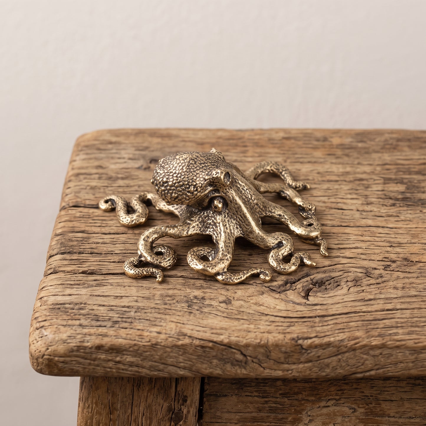 Overhead angle of a brass octopus figurine showing the sprawl of its eight arms and the cast suckers along each one