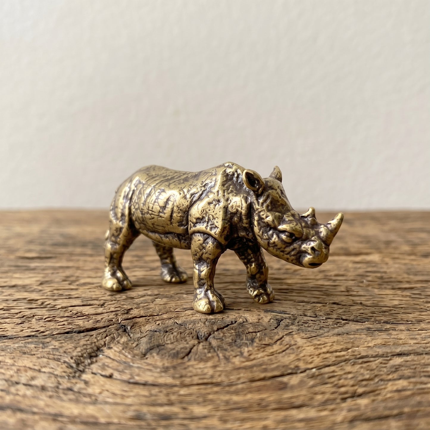The Stand miniature solid brass rhino figurine with deeply textured folded hide and aged antique patina