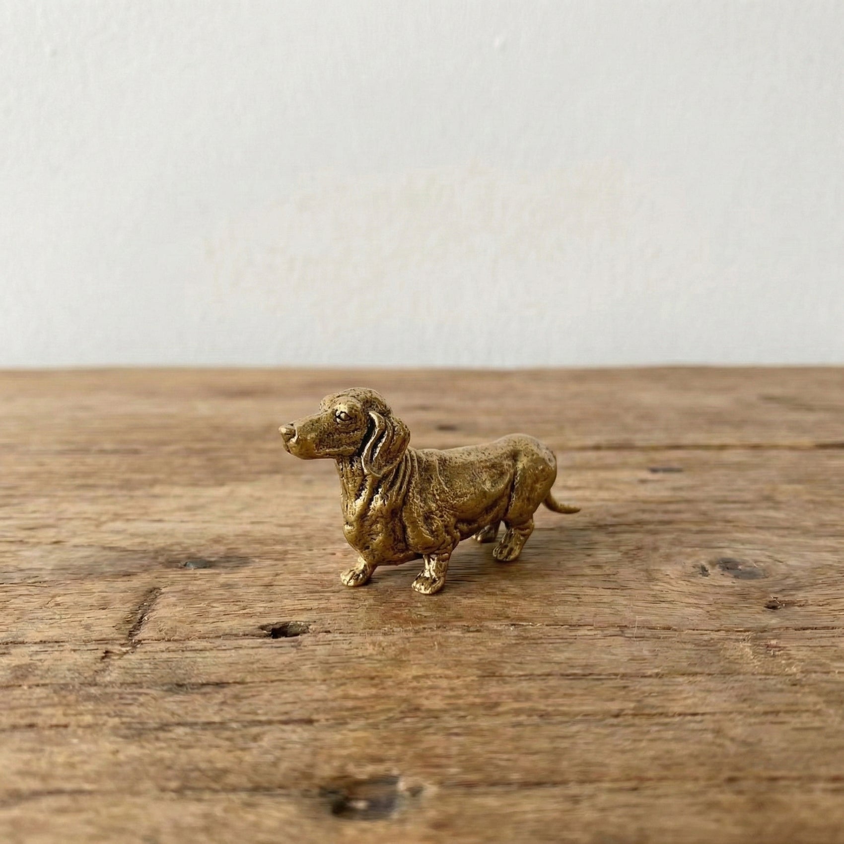 The Still Walker miniature brass dachshund figurine in walking pose showing elongated body and short legs, solid brass with aged patina, from WILLAGE Tiny Objects collection