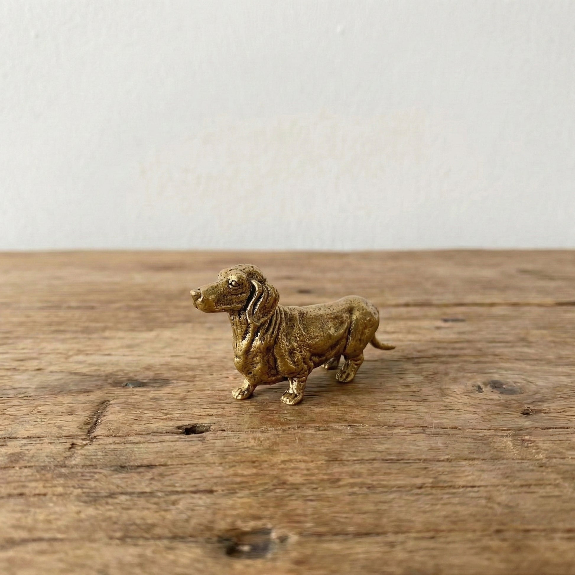 The Still Walker miniature brass dachshund figurine in walking pose showing elongated body and short legs, solid brass with aged patina, from WILLAGE Tiny Objects collection