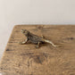 olid brass bearded dragon figurine with detailed scales and antique patina, photographed from above