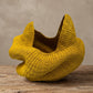 Top-down view into a yellow woven elephant-grass basket showing the interior weave and sculpted rim
