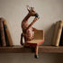 The Thinking Giraffe hand-carved wood shelf sitter perched on bookshelf between vintage books reading Reflections