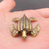The Tidal Wanderer miniature brass sea turtle with outstretched flippers and ridged shell, showing warm aged patina on a wooden surface, from the WILLAGE Tiny Objects collection