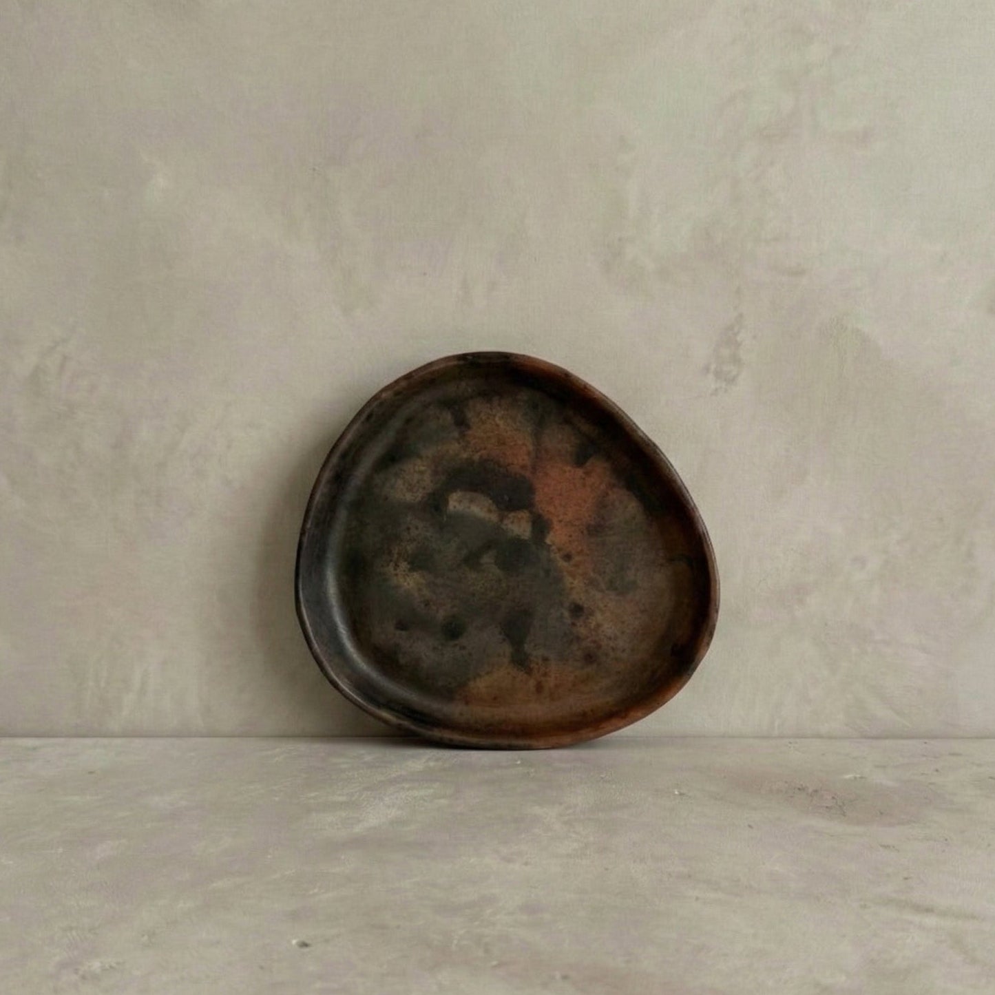 TriSung faceted triangle plate in handcrafted black clay showing organic triangular form and burnished surface, Lyrnai pottery from Meghalaya India, from WILLAGE