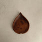 Tympew betel leaf plate in handcrafted black clay showing organic leaf-shaped form and burnished surface, Lyrnai pottery from Meghalaya India, from WILLAGE