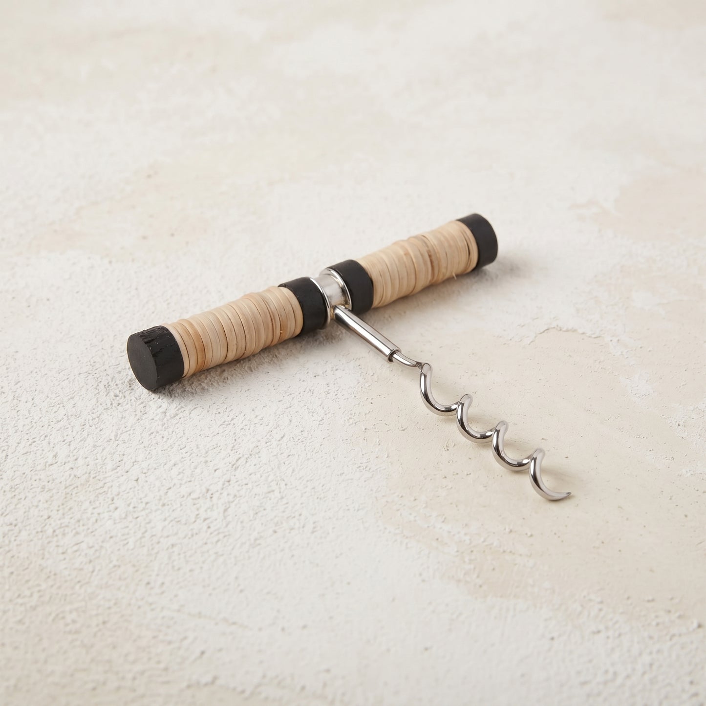 Pull-style corkscrew with a black mango wood and natural rattan wrapped handle and a stainless steel worm
