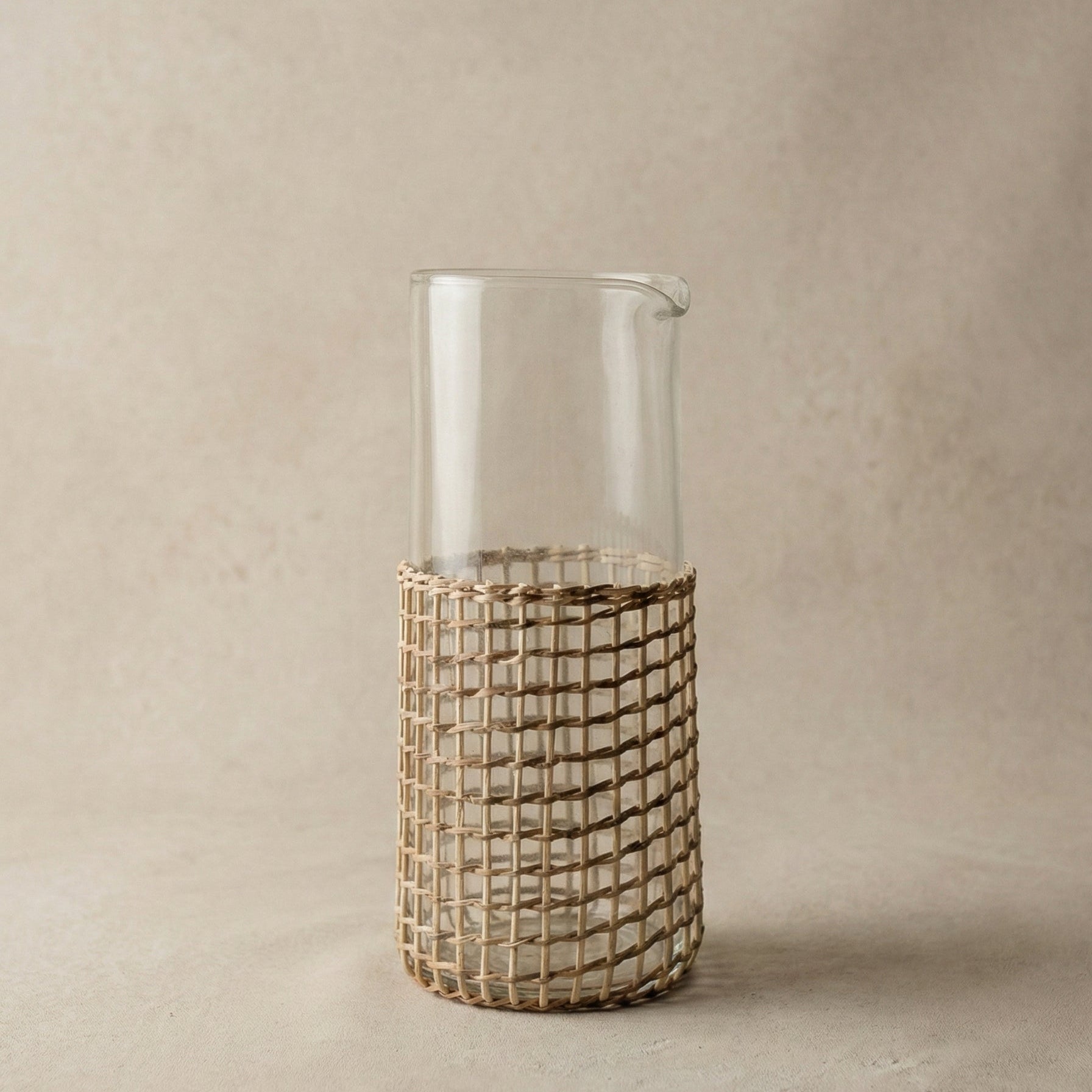 The Weaver's Carafe recycled glass carafe with hand-woven cane sleeve showing natural weave pattern, handcrafted in India, from WILLAGE
