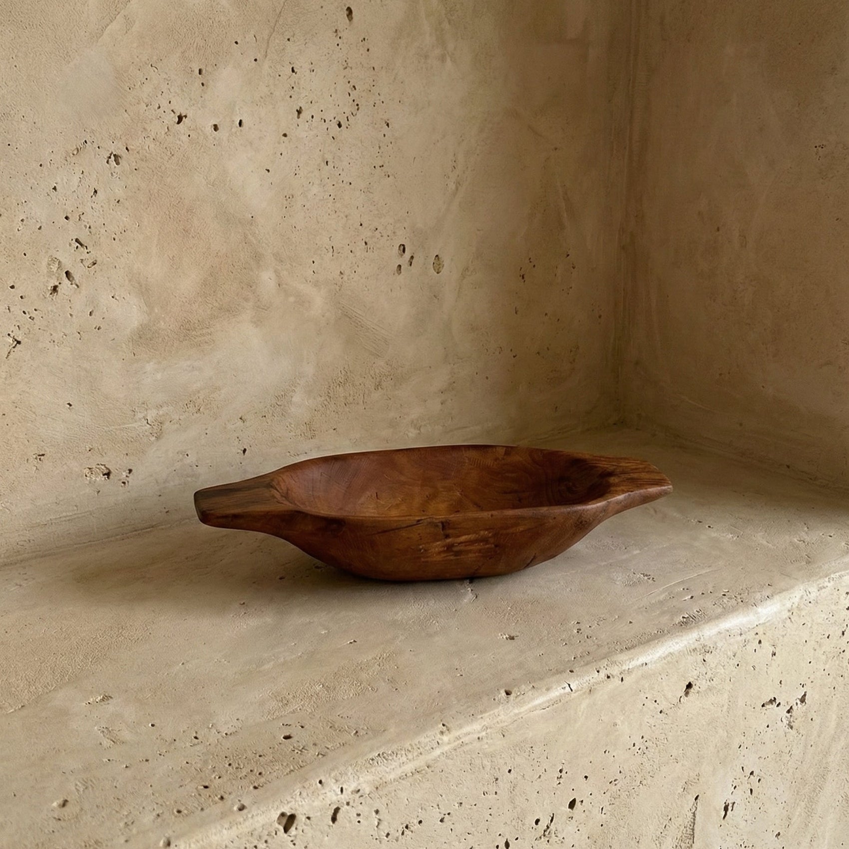 Wooden bowl on a textured stone surface