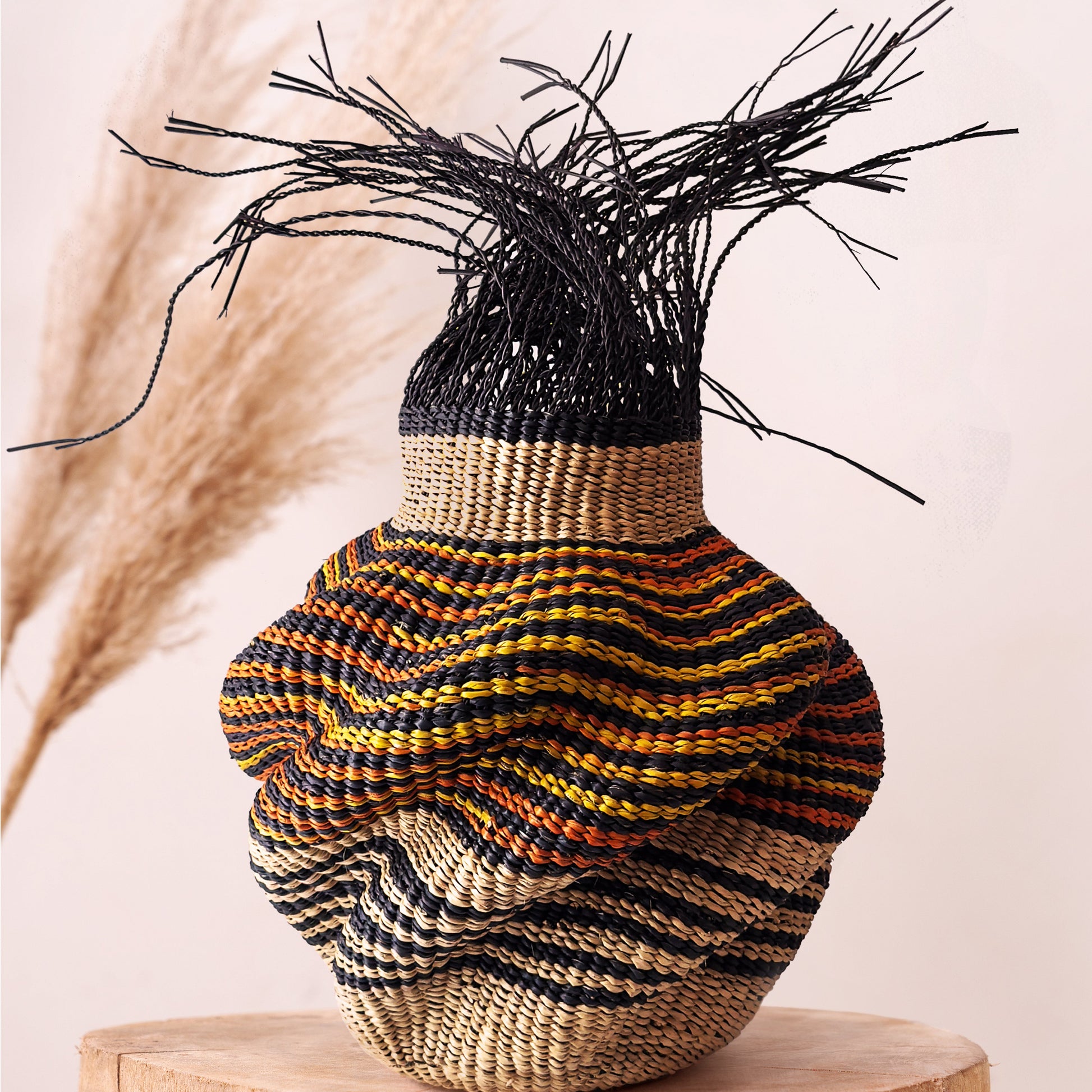 A woven Bolga basket displayed on a white surface with natural lighting from a window in the background.