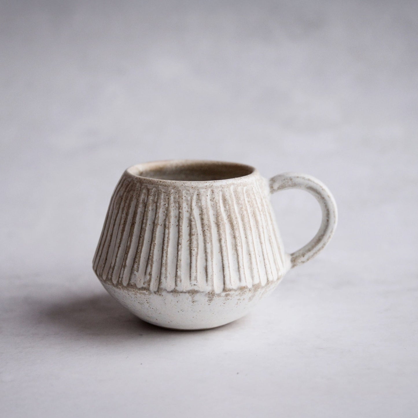 Ceramic mug with textured design on a plain background