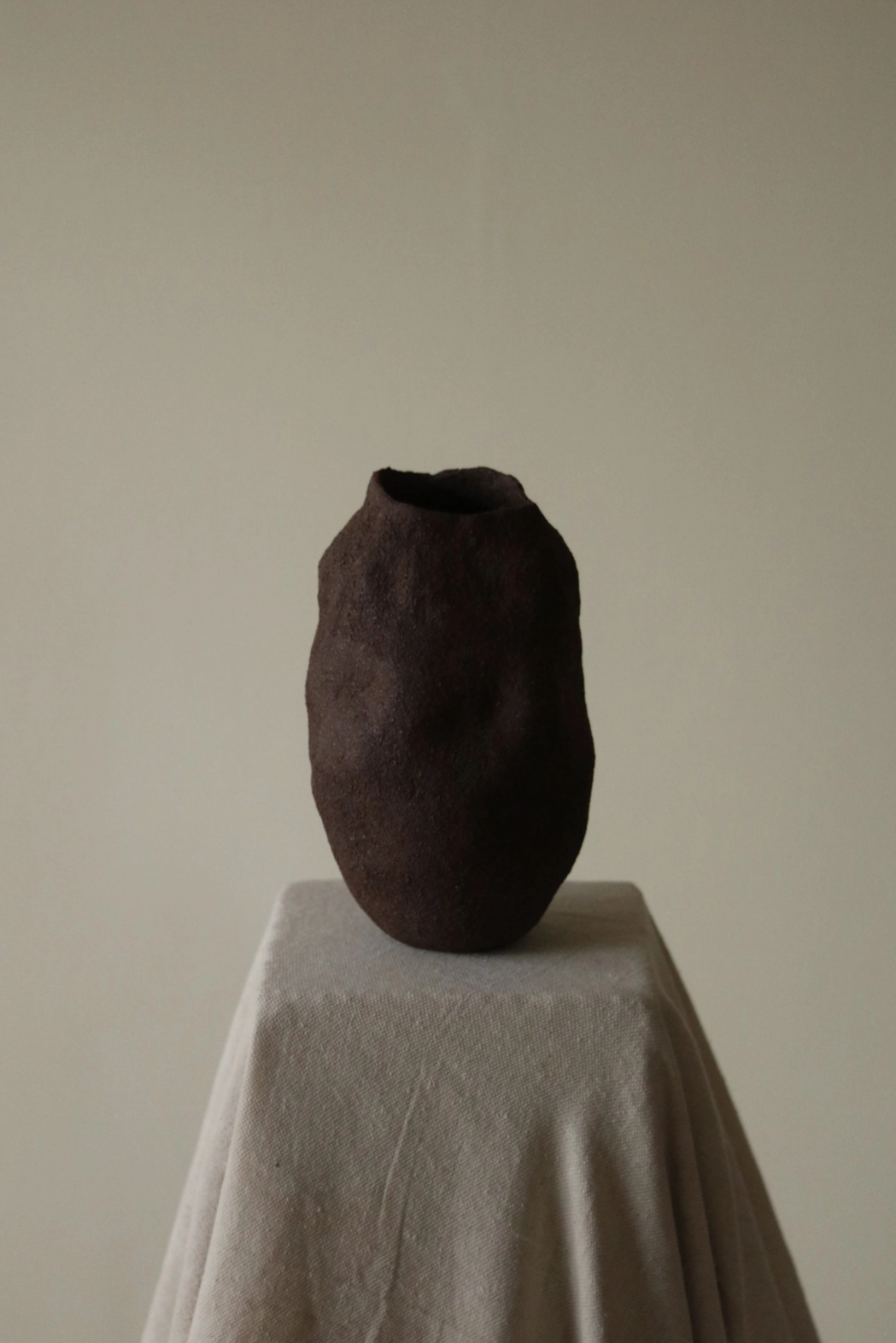 Earth-toned ceramic object with textured surface, handmade and unglazed