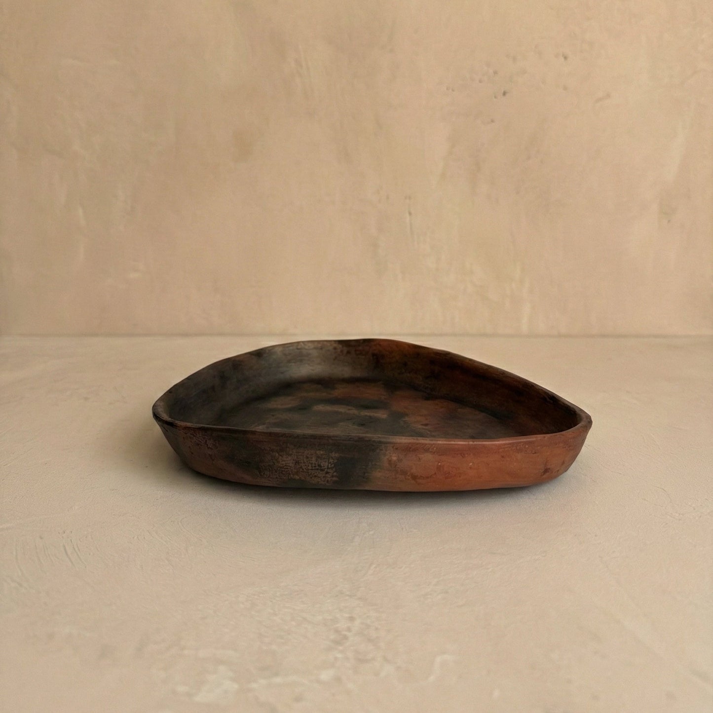 clay tray with a worn surface on a beige background