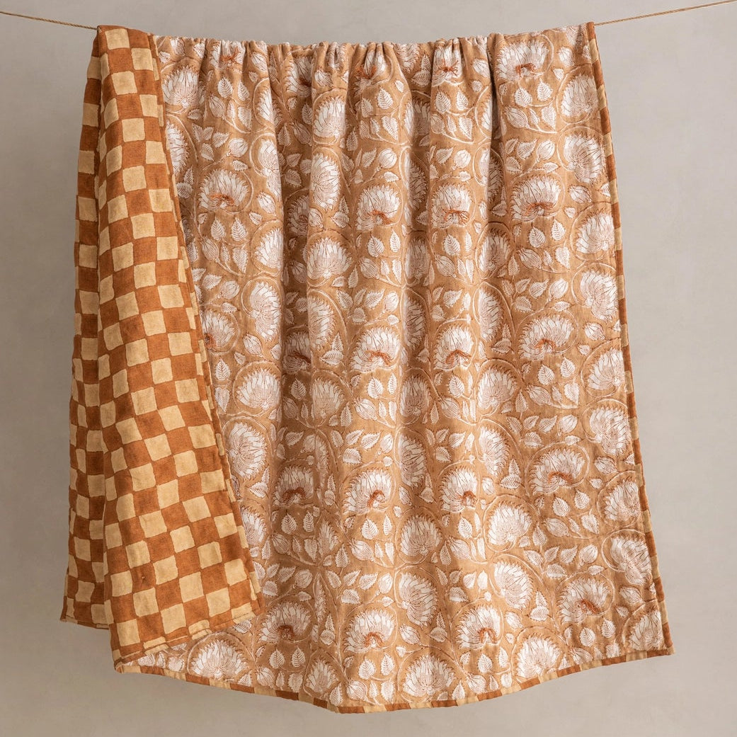Detail of reversible side of Marigold linen quilt showing hand-block printed checkerboard pattern in terracotta and natural tones