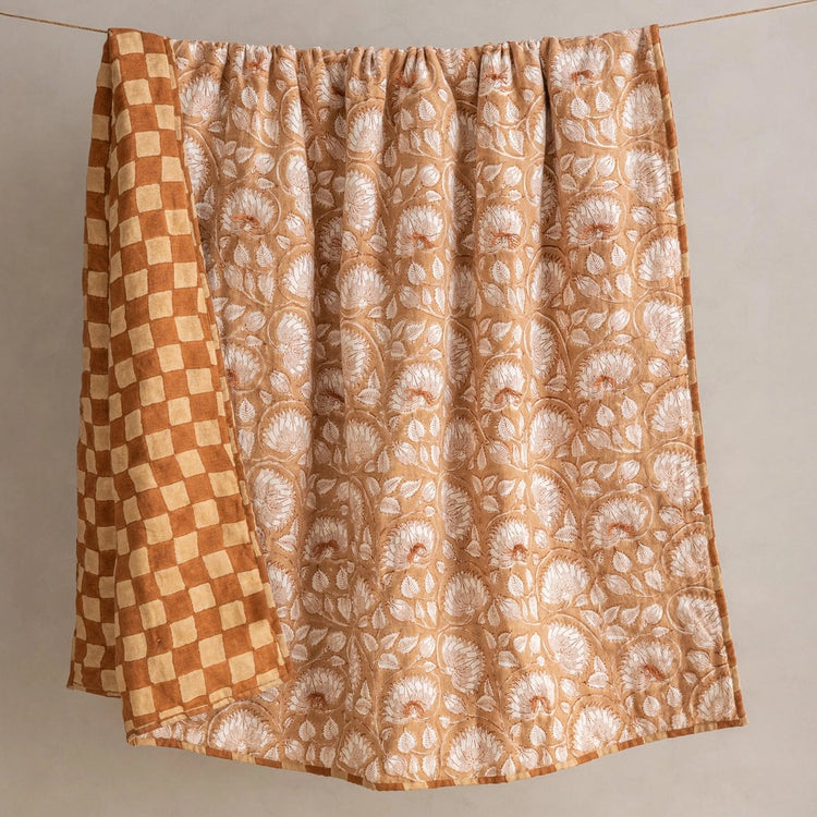 Detail of reversible side of Marigold linen quilt showing hand-block printed checkerboard pattern in terracotta and natural tones
